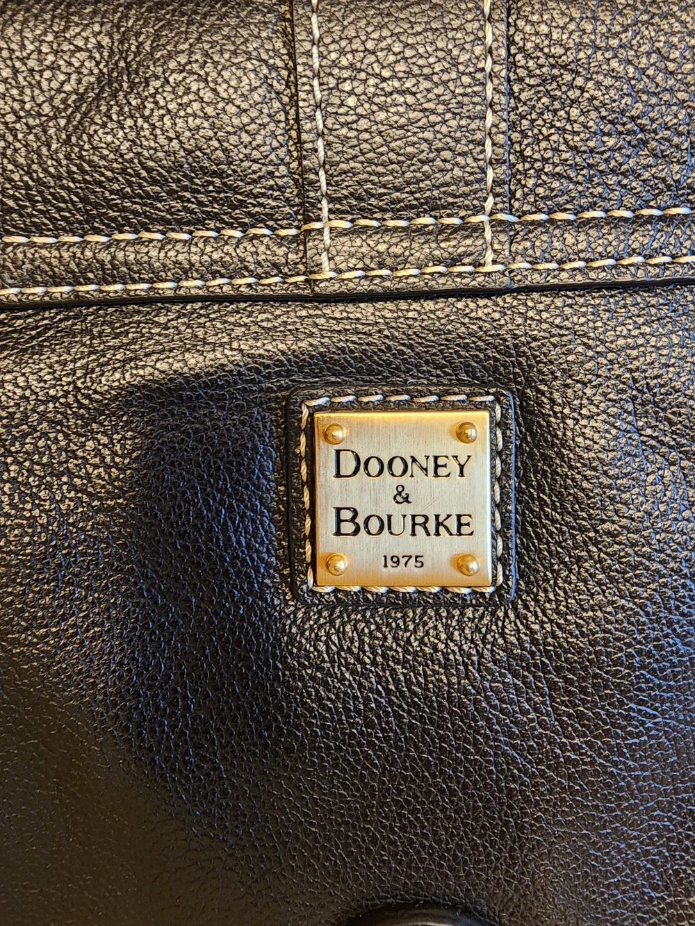 vintage Dooney & Bourke black leather shoulder bag featuring gold-tone hardware
